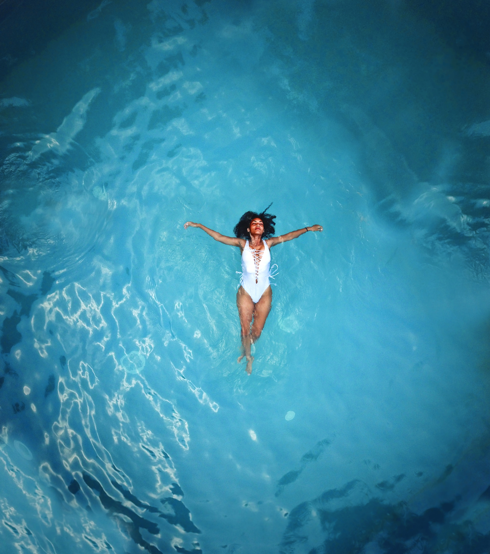 Woman in White Monokini Swimming on Body of Water